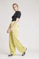 Pantalón de vestir color verde oliva, de corte ancho y tiro alto, con bolsillos laterales tipo cargo y detalle de pinzas en la cintura.