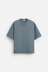 Sudadera azul de corte relaxed fit, confeccionada en tejido interlock de algodón con elasticidad. Tiene cuello redondo, manga corta y bajo con acabado en rib.