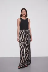 Pantalón de viscosa con estampado abstracto en tonos beige y negro, de corte palazzo y cintura con lazo ajustable.