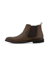 Bota corta tipo Chelsea de cuero marrón oscuro, con elástico lateral en color marrón más oscuro y suela de goma negra de bajo perfil.