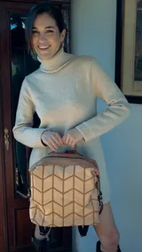 Mochila color topo agamuzada con detalle tramado al frente, apertura superior con cierre metálico, división al medio y bolsillos internos. Incluye correa corta de mano y correas regulables para colgar en la espalda.