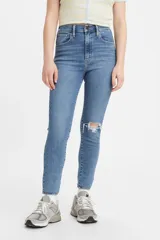 Jeans de tiro alto color celeste, ajustados en cadera y muslos, con pierna súper ajustada y rotura en la rodilla.