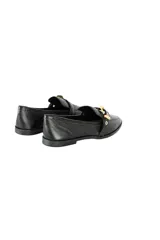 Mocasines negros de cuero con textura, punta almendrada y aplique de tira de cuero con hebilla metálica dorada.