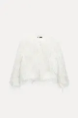 Chaqueta de pelo sintético color blanco, de cuello redondo y manga larga. Tiene bolsillos delanteros, forro interior y cierre frontal con ganchos metálicos forrados.