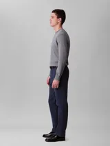 Pantalón chino de corte slim color azul marino, confeccionado en algodón y elastano. Presenta cierre con cremallera y botón, diseño clásico de cuatro bolsillos y logo de Calvin Klein bordado en la parte posterior.