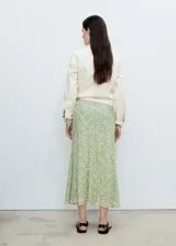 Falda midi negra de gasa con estampado de pequeñas flores blancas.
