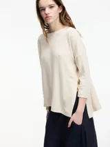 Sweater color crema de corte amplio, con cuello redondo y tajos laterales.