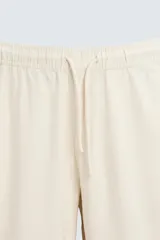 Pantalón verde oscuro de algodón con textura, corte recto, cintura elástica ajustable con cordón, bolsillos laterales y traseros de vivo.