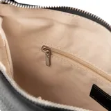 Bandolera negra de cuero sintético con textura graneada, formato plano y cierre superior. Tiene correa regulable y asa fija, herrajes plateados, un compartimento principal y bolsillos internos, uno con cierre y otro abierto.