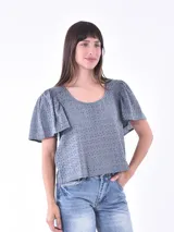 Blusa celeste con calados, mangas cortas con volados y escote redondo.
