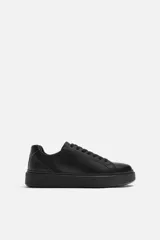 Zapatilla de cordones monocolor negra con suela con volumen.