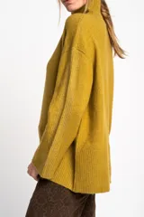 Polera color crema de tejido de punto, con cuello alto y mangas largas.