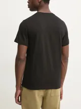 Remera negra de algodón con cuello redondo y mangas cortas. Presenta el logo de Calvin Klein estampado en el pecho dentro de un recuadro blanco con efecto desgastado.