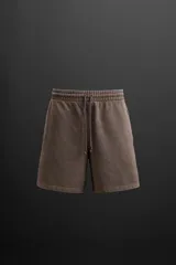 Bermuda jogger negra confeccionada en tejido de algodón con interior de rizo, cintura elástica ajustable con cordón y bolsillos laterales.