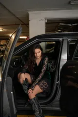 Vestido corto negro de terciopelo con escote en V, mangas largas de encaje y falda con volantes de encaje.