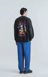 Buzo negro de frisa con calce oversize y estampa de Mickey Mouse vestido de chef sobre un círculo azul.
