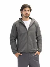 Campera rompevientos negra, liviana y funcional, con capucha ajustable, cierre frontal y dos bolsillos laterales con cierre. Posee forro interno de red para mejor ventilación.