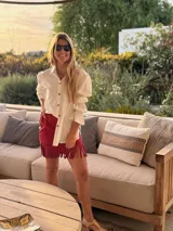 Camisa blanca con lunares negros, de mangas largas abullonadas con puños elastizados y cierre frontal con botones.