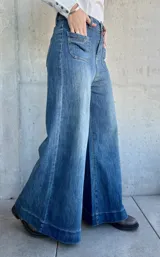 Pantalón de jean azul de corte pata de elefante, con bolsillos frontales tipo parche.