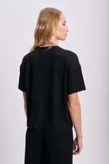 Remera negra de lanilla con corte oversize y mangas cortas.