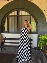 Vestido largo con estampado de zigzag blanco y negro, con cuello halter y falda amplia con volantes en el ruedo.