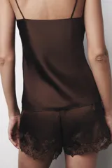 Shorts de tiro alto confeccionados en tejido satinado color marrón chocolate, con cintura elástica y detalle de bordados florales y encaje a tono en el ruedo.