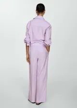 Pantalón wideleg color lila con rayas verticales, de tejido mezcla de poliéster y lino. Tiene trabillas, dos bolsillos laterales y dos bolsillos de ribete en la parte posterior.