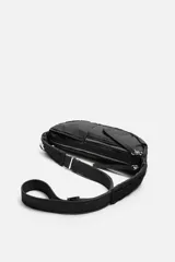 Bandolera negra de tela técnica con correa ajustable. Tiene un compartimento principal con cierre de cremallera, un bolsillo interior plano con cremallera y dos bolsillos frontales, uno de ellos con cremallera.
