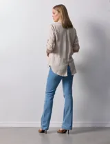 Camisa color beige de tencel, marca Hester & Orchand. Cuello con solapa, escote en V y abertura central con botones. Delantera con bolsillos. Largo de manga regulable con presilla y botón.