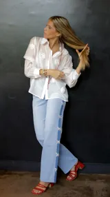 Pantalón de jean celeste con spandex y detalle de apliques de mariposas plateadas en los laterales. Corte recto y tiro medio.