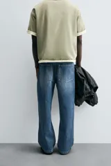 Pantalón de jean azul de tiro medio, corte flare, con cinco bolsillos y cierre frontal con cremallera y botón.