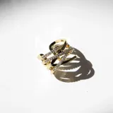 Anillo dorado entrelazado en acero con cristales de Cubic Zirconia y acabado en oro 18k.