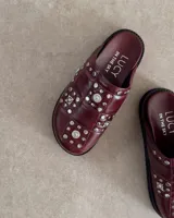 Zuecos negros con apliques de tachas plateadas y strass.