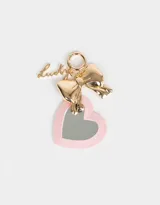 Llavero con dije de espejo en forma de corazón con borde rosa, moño dorado y dije con la palabra "Lucky".