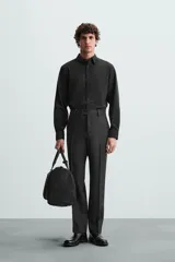 Camisa negra de manga larga, corte slim fit, con cuello italiano y cierre frontal de botonadura.