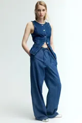 Pantalón de denim azul de corte holgado, con cintura elástica ajustable con cordón, bolsillos laterales y piernas anchas.