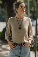 Top color beige de tejido de punto, con cuello redondo y mangas cortas tipo capa.
