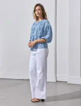 Blusa celeste con estampado floral blanco, escote en V y botones. Mangas 3/4 abullonadas con terminación elastizada.