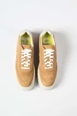 Zapatillas urbanas blancas con suela de plataforma track y detalle de pespuntes.