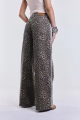 Pantalón de jean de corte ancho con estampado animal print y rayas blancas laterales.