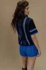 Saco tejido a crochet a mano con detalles en azul y amarillo.