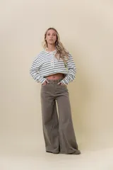 Pantalón de denim color marrón, de tiro medio-alto y calce wide leg con pierna amplia.