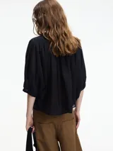 Camisa negra de algodón con cuello mao y botones frontales. Tiene mangas 3/4 amplias y un corte recto.