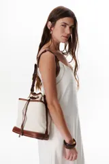 Vestido largo color crudo con breteles finos y costuras a la vista en color azul.