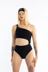 Malla enteriza negra asimétrica con un solo hombro y abertura en la zona abdominal.