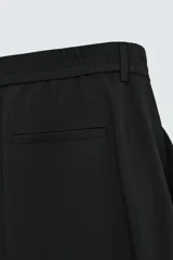 Pantalón de vestir color beige, corte wide fit, con cintura elástica, pliegues frontales, bolsillos laterales y traseros de vivo.