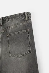 Pantalón de jean negro de corte amplio, con cinco bolsillos, efecto lavado y cierre frontal con cremallera y botón.