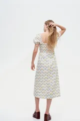 Vestido largo de algodón con estampado floral, escote cuadrado, cuerpo fruncido, mangas cortas abullonadas y falda con leve vuelo.