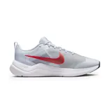 Championes Nike Downshifter 12, color gris claro con detalles en rojo y suela blanca.
