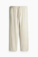 Pantalón de lino color crema, con cintura elástica y cordón ajustable.